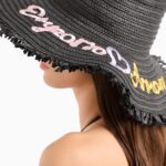 Cappello modello fedora in papier a lavorazione intrecciata, caratterizzato da maxi ricamo a contrasto con logo e tesa a profilo sfrangiato.