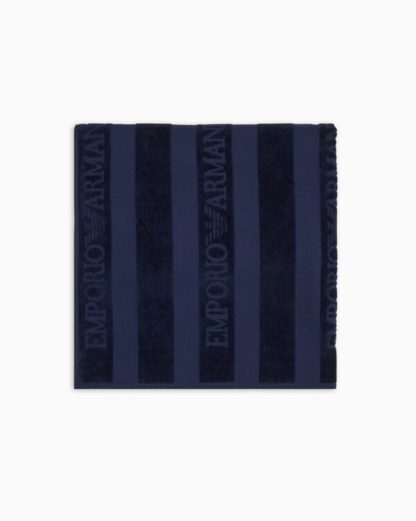 Telo mare realizzato in spugna di cotone con motivo a righe verticali e logo jacquard decorativo emporio armani